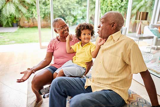 Grandparents cuddling with their grandson